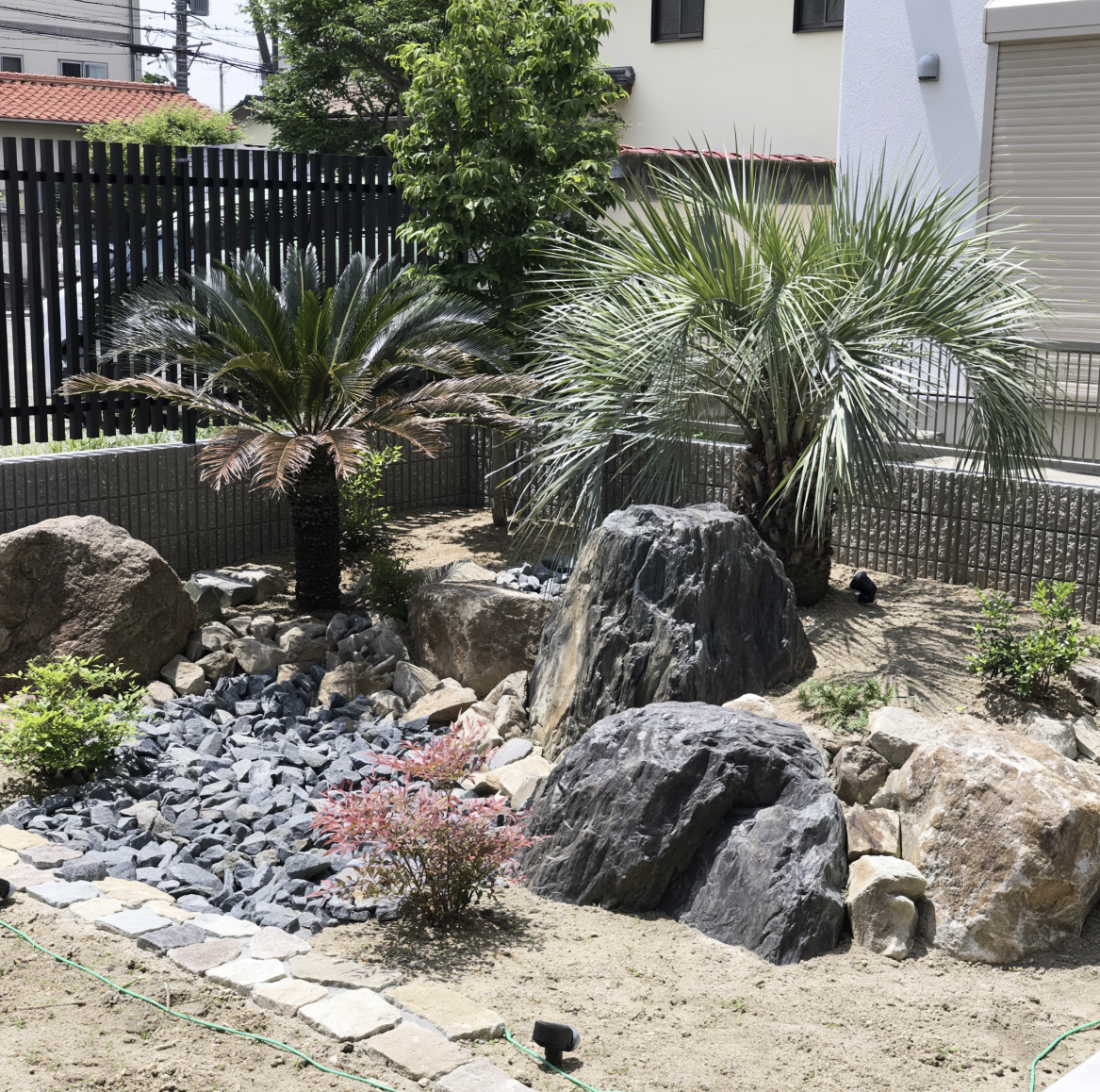 Rock garden landscaping with palms, feature boulders and slate gravel bed, built by GP FloraL